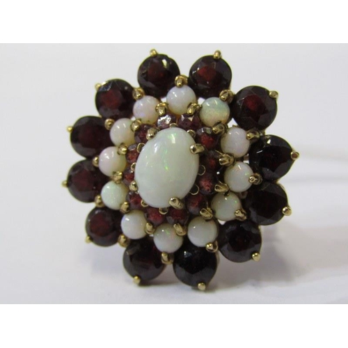 122 - IMPRESSIVE 9ct YELLOW GOLD GARNET & OPAL CLUSTER RING, principal oval cut opal surrounded by a halo ... 