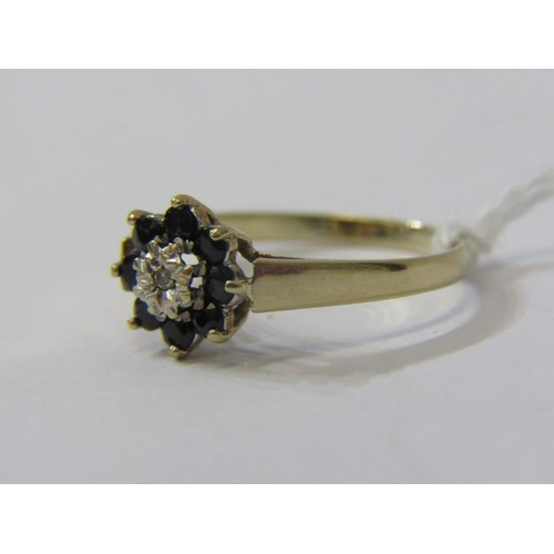 125 - 9ct YELLOW GOLD SAPPHIRE & DIAMOND CLUSTER RING, principal brilliant cut diamonds surrounded by dark... 