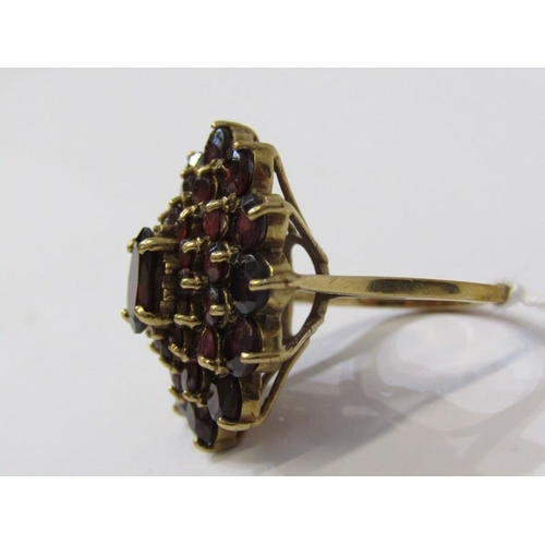 127 - IMPRESSIVE LARGE GARNET CLUSTER RING, principal oval cut garnet surrounded by concentric ovals of in... 