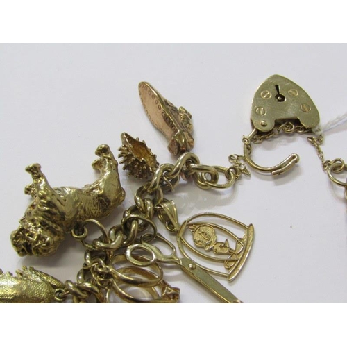 174 - 9ct GOLD CHARM BRACELET, approx. 26 charms in total, weighing 65.9 grams, charms including bulldog, ... 