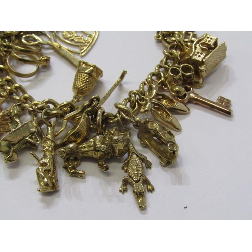 174 - 9ct GOLD CHARM BRACELET, approx. 26 charms in total, weighing 65.9 grams, charms including bulldog, ... 