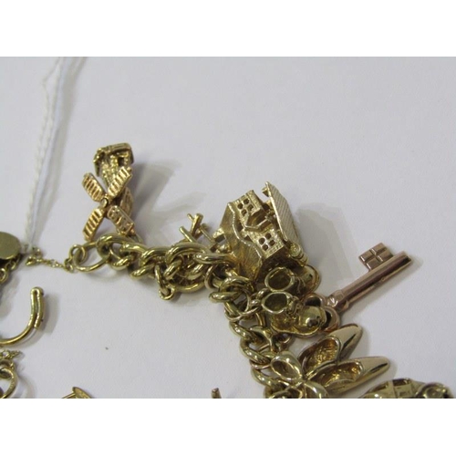 174 - 9ct GOLD CHARM BRACELET, approx. 26 charms in total, weighing 65.9 grams, charms including bulldog, ... 