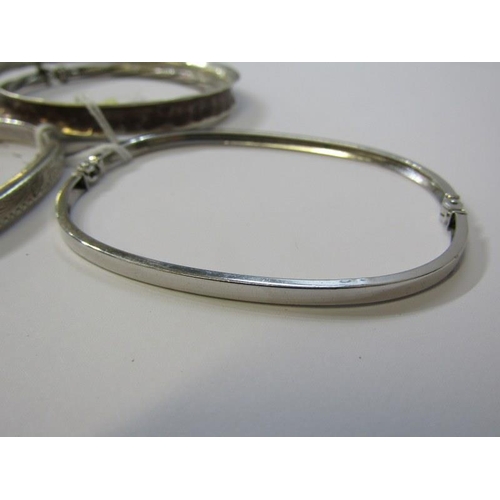 140 - SILVER BANGLES, 4 assorted silver bangles, including 2 hinged bangles and 2 others with engraved dec... 