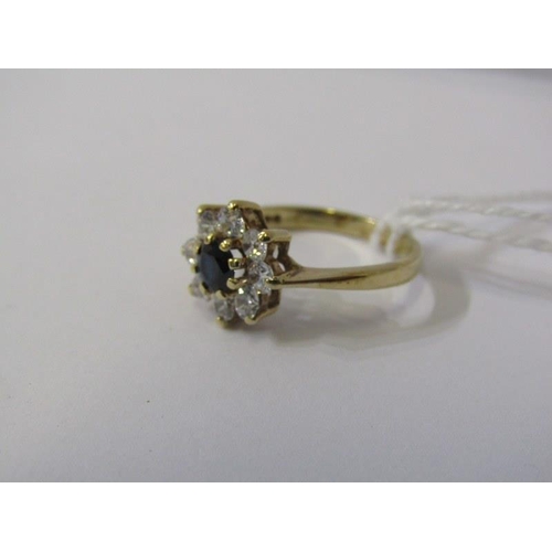 215 - 9ct GOLD CLUSTER RING, 9ct yellow gold ring set a blue stone to centre with clear stones to the oute... 