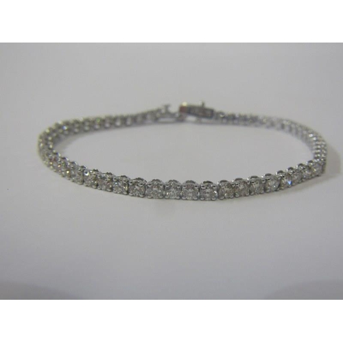 34 - SUPERB DIAMOND LINE BRACELET, 18ct white gold bracelet set 54 well matched round brilliant cut diamo... 