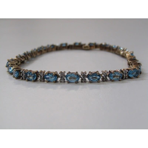 224 - DIAMOND & BLUE TOPAZ BRACELET, 9ct yellow gold bracelet, set well matched oval blue topaz, intersper... 