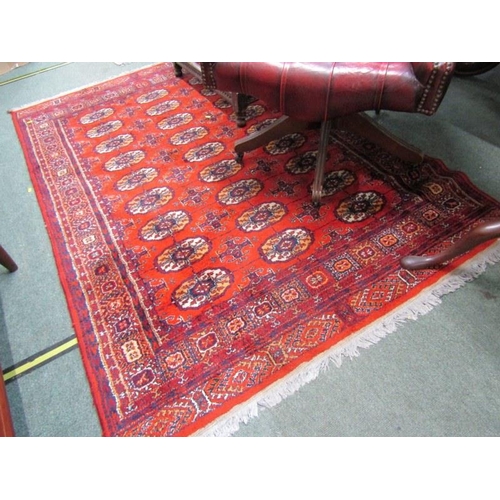 863 - EASTERN RUG, decorated multi medallions on a red ground, within multiple borders, 198cm length