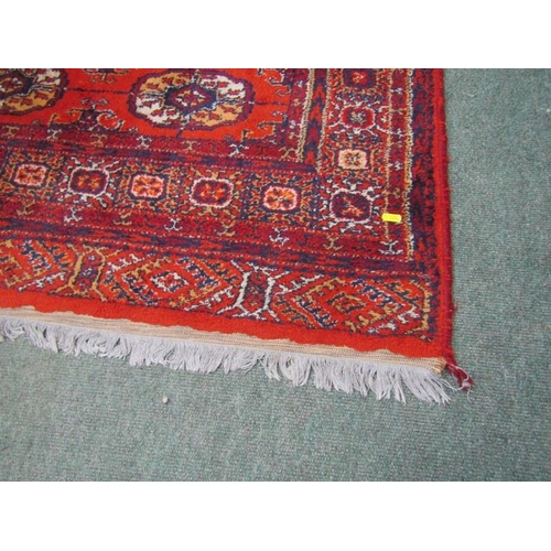 863 - EASTERN RUG, decorated multi medallions on a red ground, within multiple borders, 198cm length