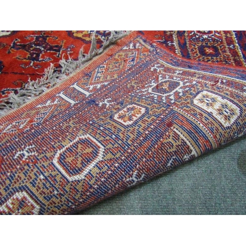 864 - MIDDLE EASTERN CARPET, Middle Eastern hand knotted rug, decorated multiple medallions on a red groun... 