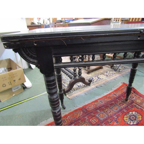 866 - EDWARDIAN CARD TABLE, ebonised folding card table, on turned supports and castor feet, 90cm width