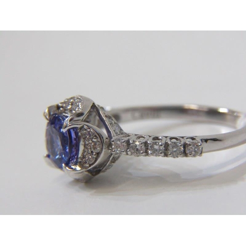 12 - TANZANITE & DIAMOND CLUSTER RING, 18ct white gold ring set a central circular tanzanite, within a cl... 