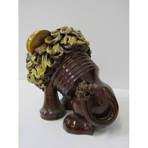 380 - STUDIO POTTERY, a comical slip glazed figure of lion, 19cm height