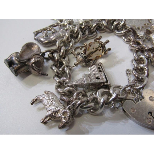 176 - SILVER CHARM BRACELET, curb link bracelet with padlock clasp, approx. 12 charms, 91.8 grams