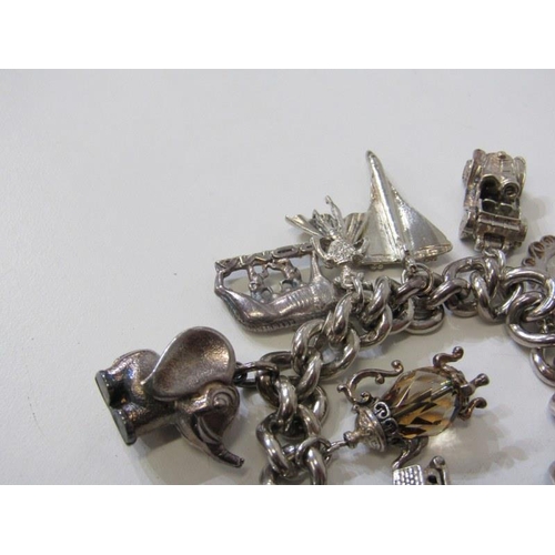 176 - SILVER CHARM BRACELET, curb link bracelet with padlock clasp, approx. 12 charms, 91.8 grams