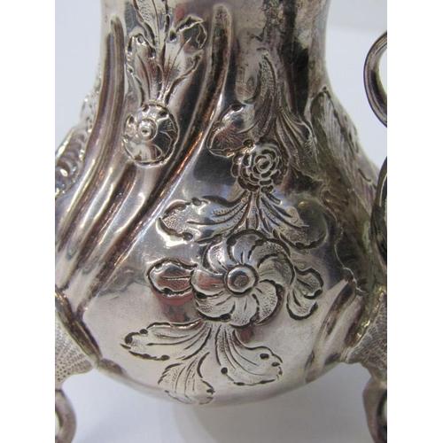 250 - GEORGE III SILVER EMBOSSED CREAM JUG, on tripod feet, London possibly 1763, 91 grams