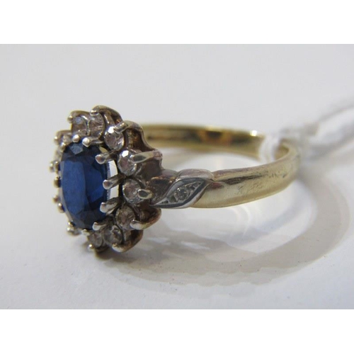 143 - SAPPHIRE CLUSTER RING, oval sapphire surrounded by a cluster of clear stones on a yellow gold mount,... 