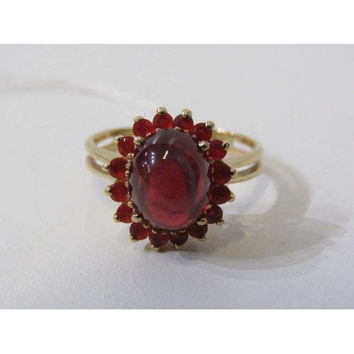 254 - GARNET & FIRE OPAL RING, 9ct yellow gold ring set a cabochon garnet, surrounded by a cluster of fire... 