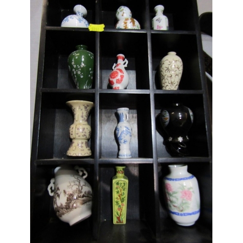 415 - ORIENTAL CERAMICS, 12 various small oriental vases contained in a wood stand