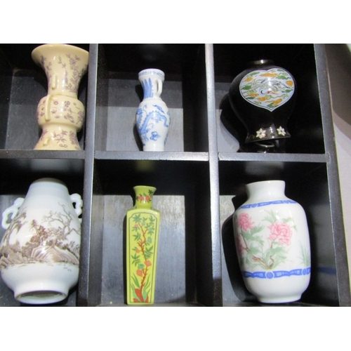 415 - ORIENTAL CERAMICS, 12 various small oriental vases contained in a wood stand