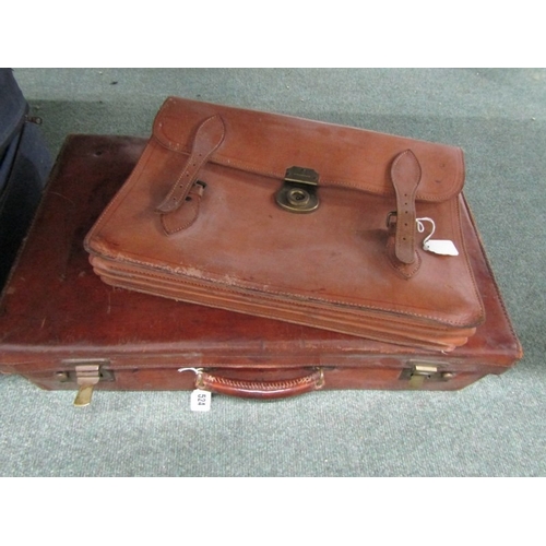 524 - LUGGAGE, An old leather suitcase with leather carrying handle with brass catches and mounts, owners ... 