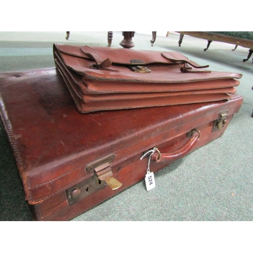 524 - LUGGAGE, An old leather suitcase with leather carrying handle with brass catches and mounts, owners ... 
