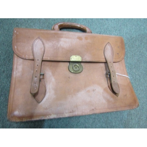 524 - LUGGAGE, An old leather suitcase with leather carrying handle with brass catches and mounts, owners ... 