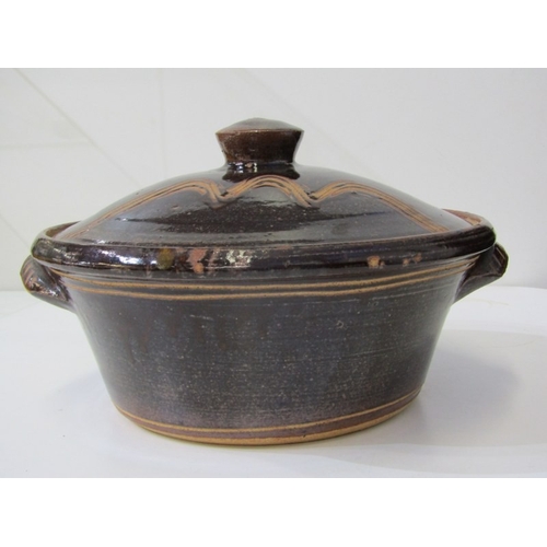 25 - WENFORD POTTERY CASSEROLE DISH, a lidded casserole dish with a dark brown glaze, incised with wavy l... 
