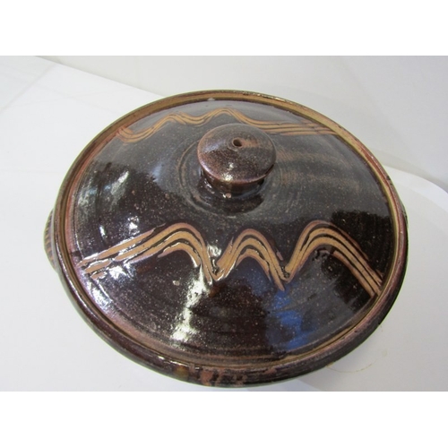 25 - WENFORD POTTERY CASSEROLE DISH, a lidded casserole dish with a dark brown glaze, incised with wavy l... 
