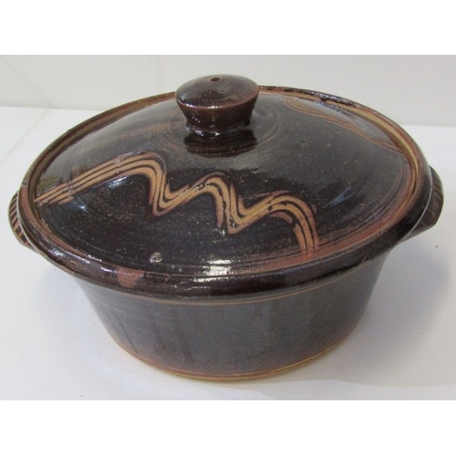 25 - WENFORD POTTERY CASSEROLE DISH, a lidded casserole dish with a dark brown glaze, incised with wavy l... 