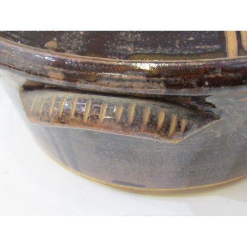 25 - WENFORD POTTERY CASSEROLE DISH, a lidded casserole dish with a dark brown glaze, incised with wavy l... 