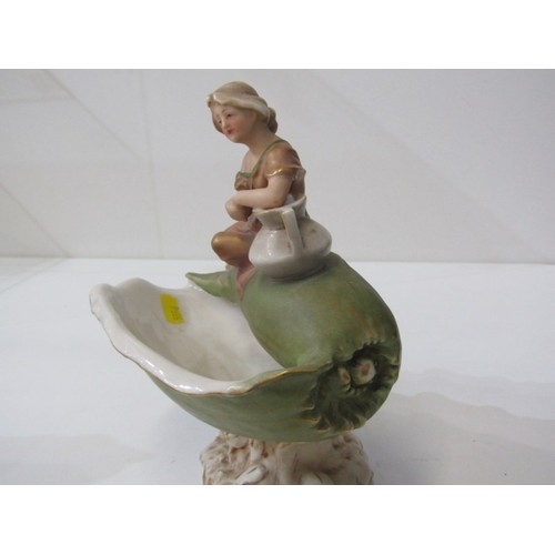 9 - ROYAL DUX, a Royal Dux Bohemia porcelain figure depicting a maiden with a water jug sitting on a lar... 