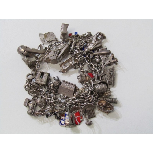 41 - EXTENSIVE SILVER CHARM BRACELET, charm bracelet with approx. 36 assorted charms of various forms, in... 