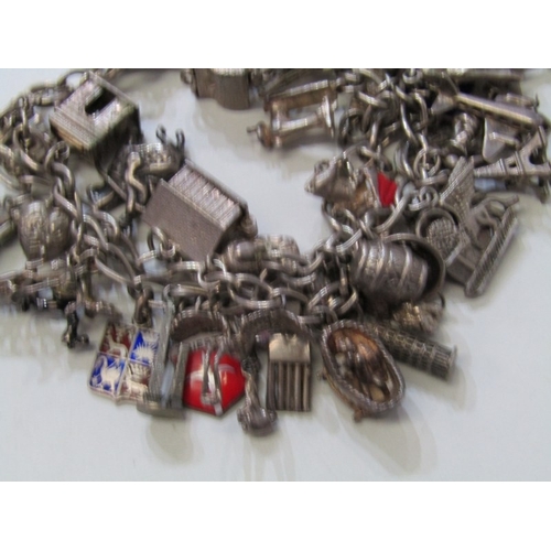 41 - EXTENSIVE SILVER CHARM BRACELET, charm bracelet with approx. 36 assorted charms of various forms, in... 