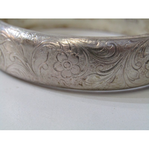 46 - SILVER BANGLE, silver hinged bangle with foliate engraved decoration, 35.4 grams