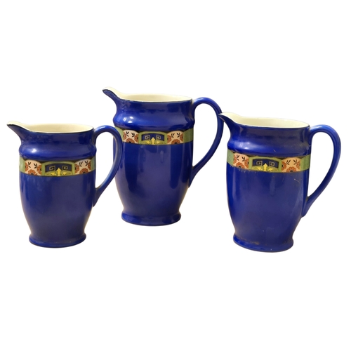 73 - Art Deco B.C.M. Nelson Ware Graduated Set of Three Cobalt Blue Pottery Jugs , each with a flared rim... 