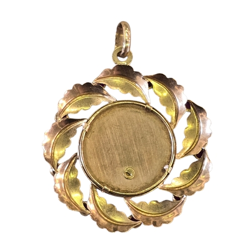 12 - A vintage Italian 18ct gold and ruby devotional pendant the circular openwork mount formed as a wrea... 