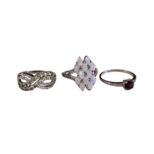 19 - A collection of 925 silver gem-set rings,comprising a green peridot crossover ring with small accent... 
