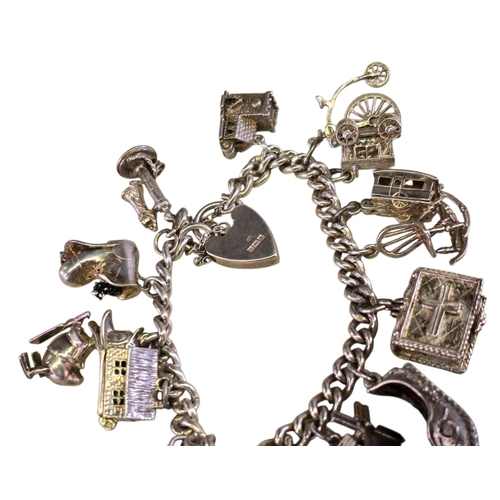 32 - A vintage 925 silver curb-link charm bracelet,
hung with a varied collection of articulated and nove... 