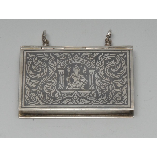 1013 - A 19th century Siamese silver and niello rectangular book shaped box, decorated with deities on a gr... 