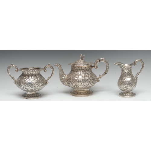 1017 - A 19th century Indian silver three piece tea service, in the manner of Oomersi Mawji, Kutch [Cutch},... 