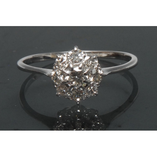 1118 - A diamond cluster ring, central round brilliant cut diamond, approx 0.20ct, surrounded by an collar ... 