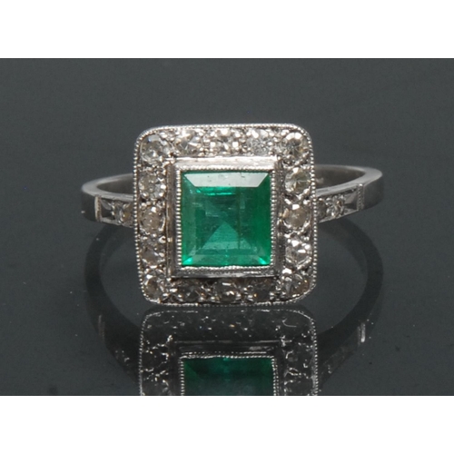 1121 - An emerald and diamond ring, central square table cut emerald approx 0.85ct, surrounded by a collar ... 