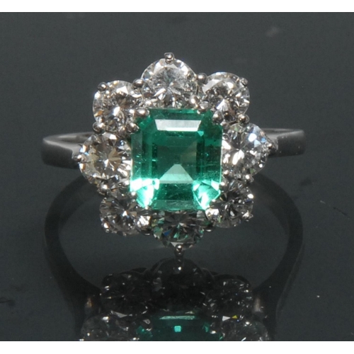 1127 - A Columbian emerald and diamond cluster ring, central rectangular cut vibrant green transparent cert... 