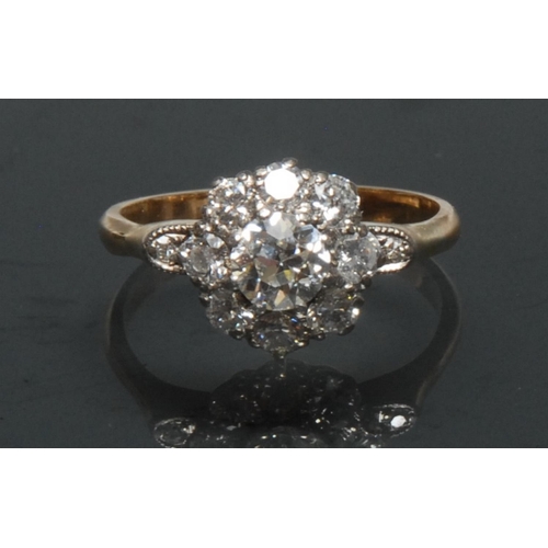 1145 - A diamond cluster ring, central round brilliant cut diamond approx 0.60ct, surrounded by a collar of... 