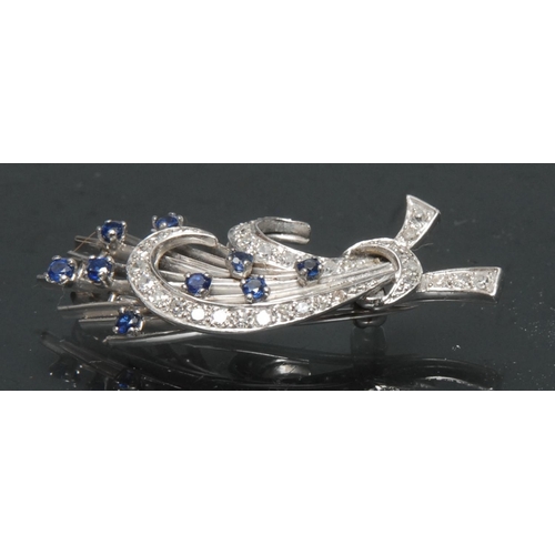 1150 - A sapphire and diamond floral spray ribbon brooch, twin curled tied ribbon crests inset with thirty ... 