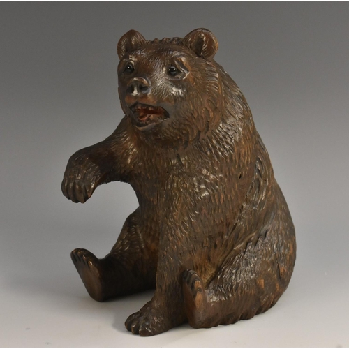 1985 - A Black Forest model of a bear, seated, with paw raised, glass eyes, 14.5cm high, c.1900