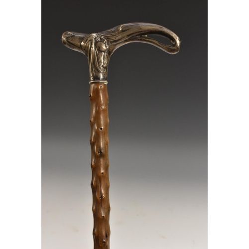 1986 - A German Art Nouveau silver mounted walking stick, the stylised L-shaped handle embossed with a fema... 