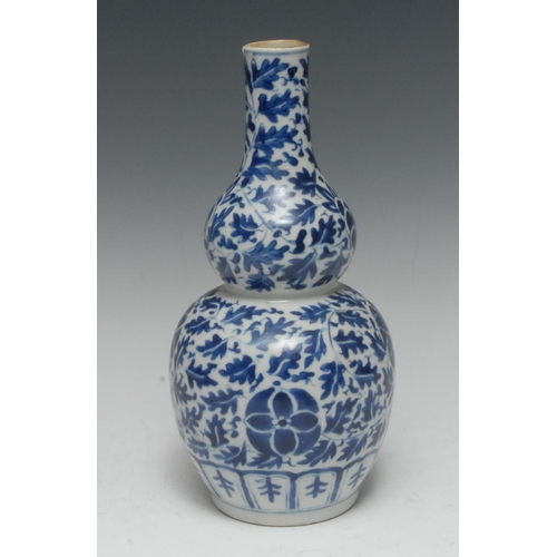 388 - A Chinese porcelain double-gourd vase, painted in underglaze blue with a peonies and leafy scrolls, ... 