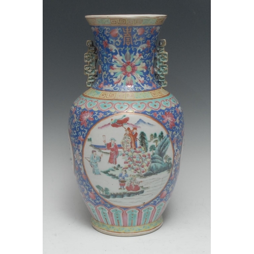 405 - A Chinese Famille Rose temple vase, painted with circular cartouche figures and foliage, the sides w... 