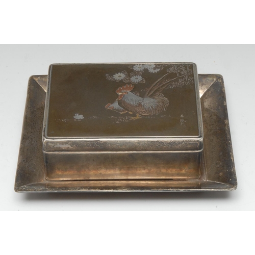 912 - A Japanese silver and mixed metal rounded rectangular box and stand, the cover decorated with cocker... 